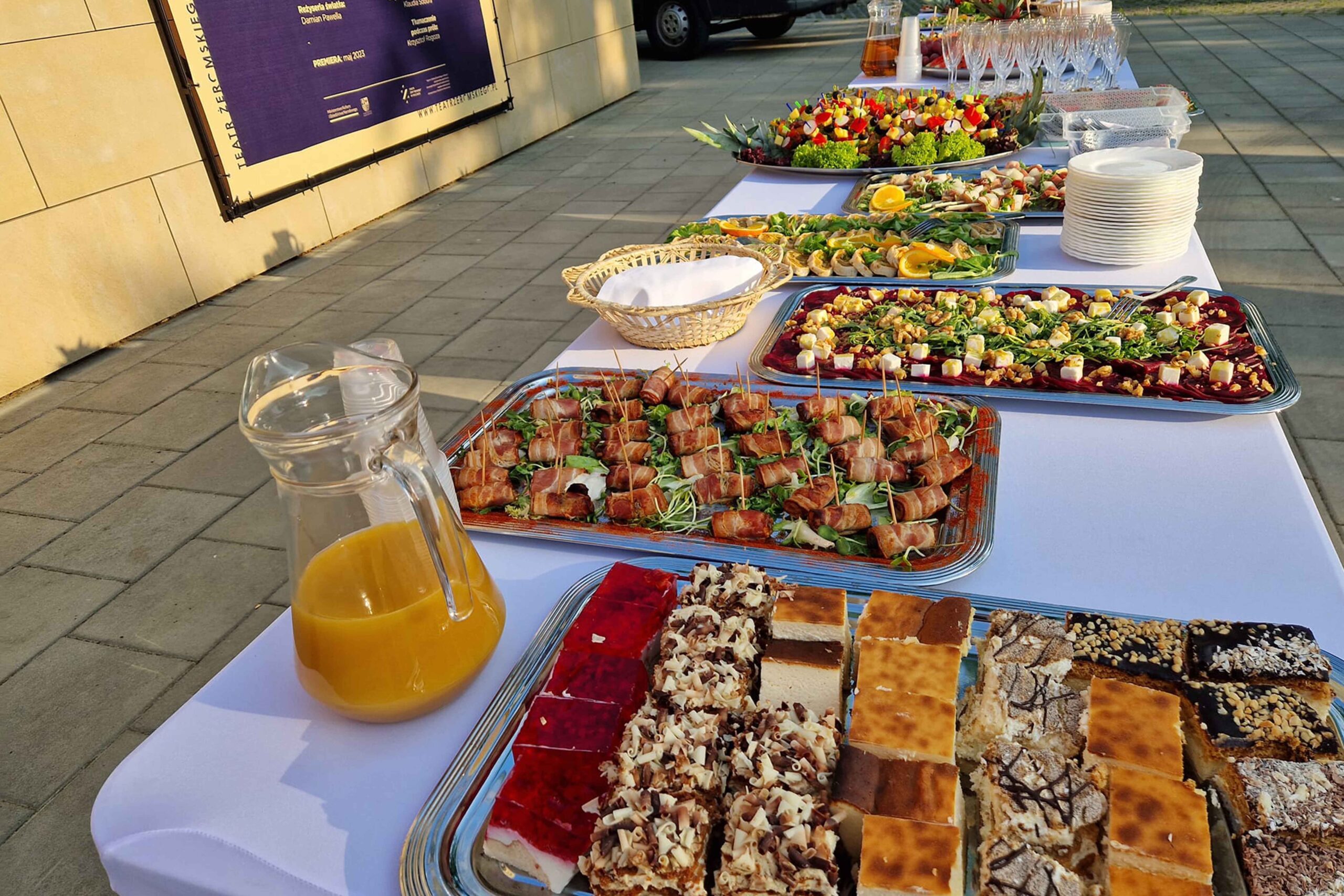 Elegancki catering plenerowy – ciasta, koreczki, przekąski i soki serwowane podczas eventu na świeżym powietrzu