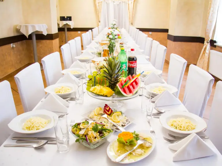 Sala przyjęć w Dworku Bobrza – elegancko nakryty stół z potrawami i dekoracjami na uroczystość okolicznościową